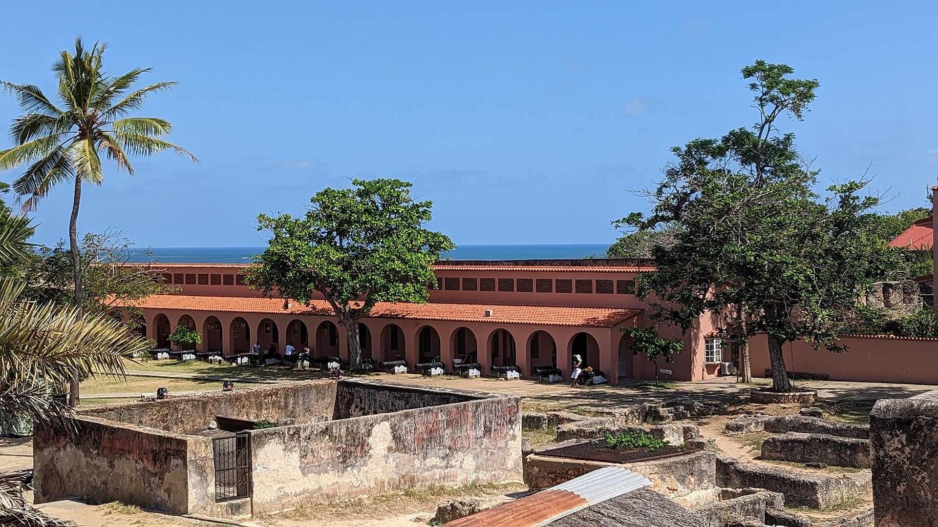 Stone courtyard and walls inside Fort Jesus with the Indian Ocean beyond